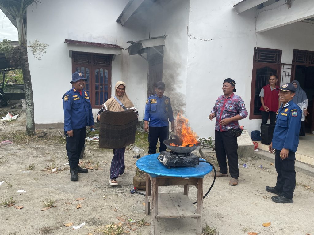 Seorang perempuan membawa lap basah yang digunakan untuk memperagakan pemadaman api