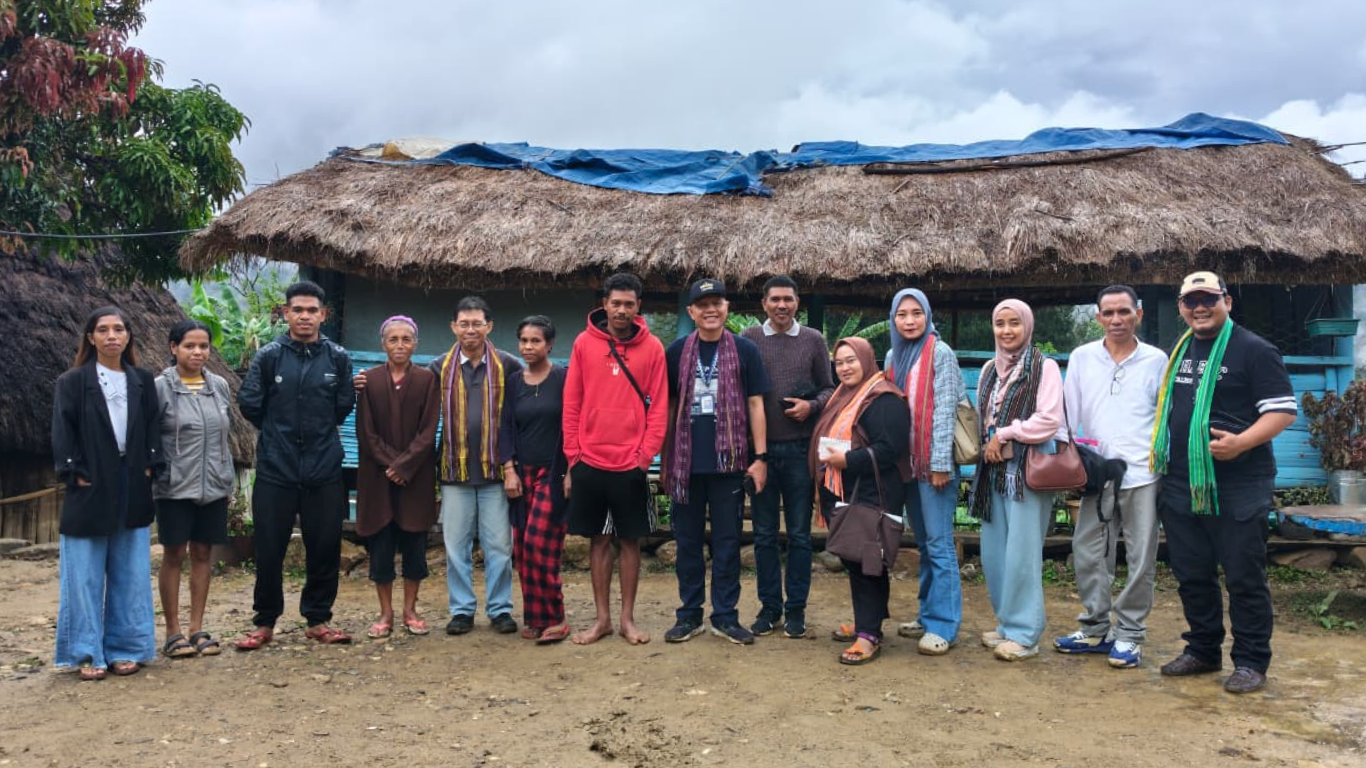 sekelompok orang sedang berpose berdiri di sebuah rumah di wilayah Timor Leste