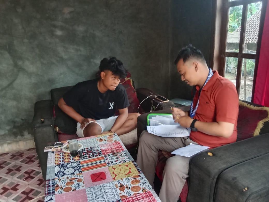 Seorang laki-laki sedang duduk di hadapan seorang pemuda tampak sedang mengisi berkas survey