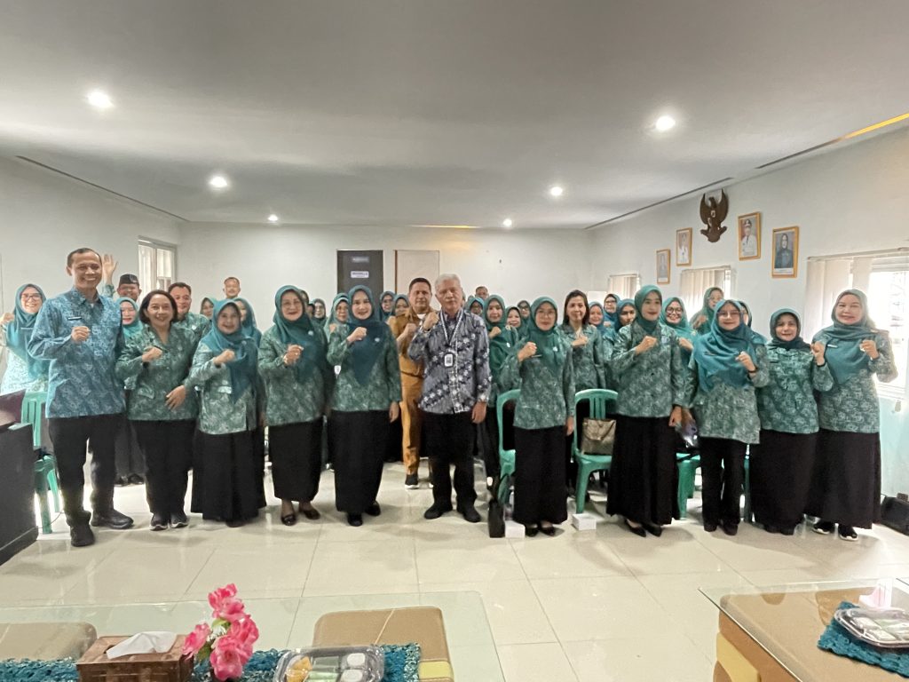 Peserta pelatihan berfoto bersama dengan tim Paluma sambil mengepalkan tangan kanan