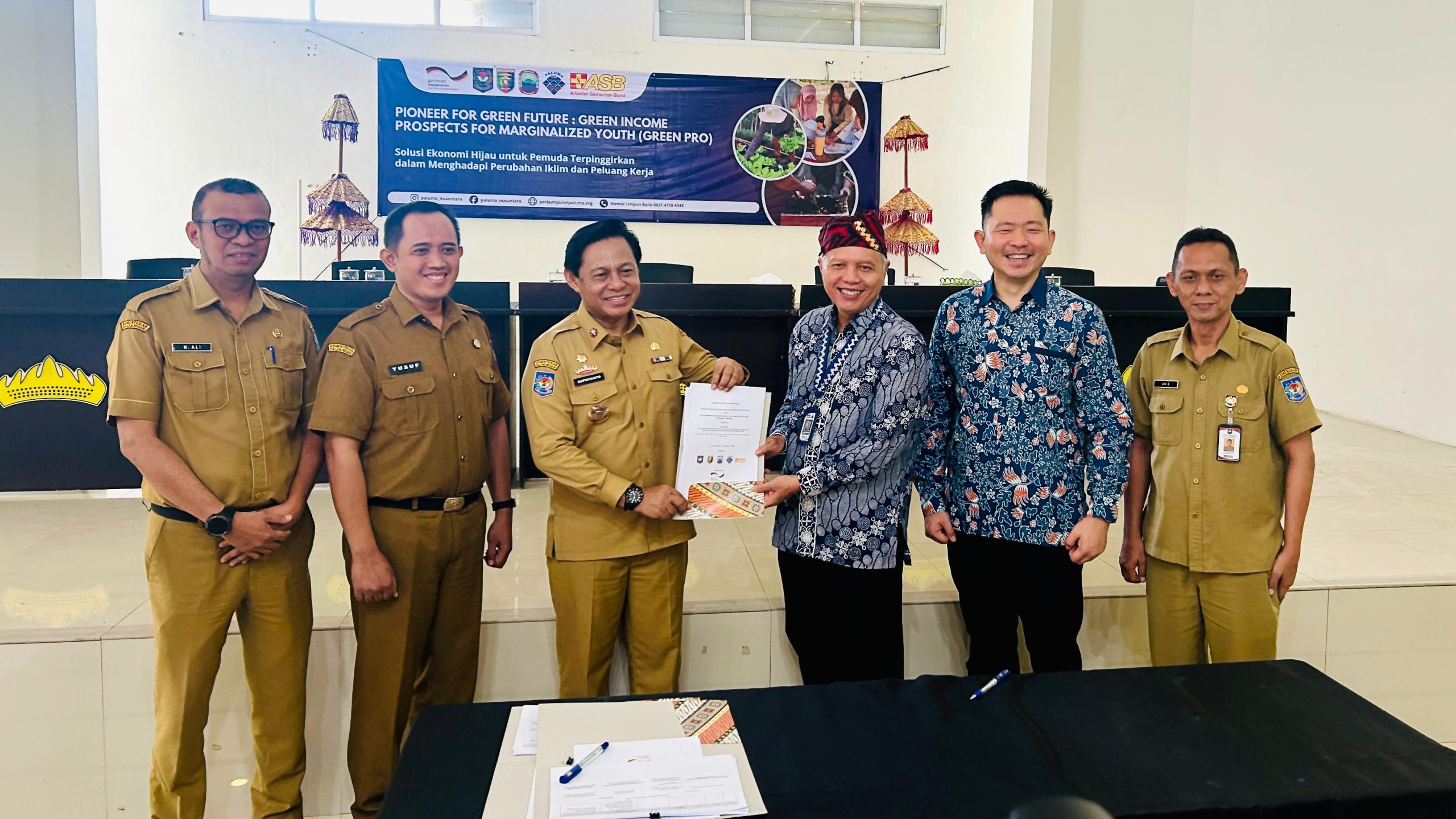 foto bersama menunjukkan dokumen yang tlah di tanda tangani